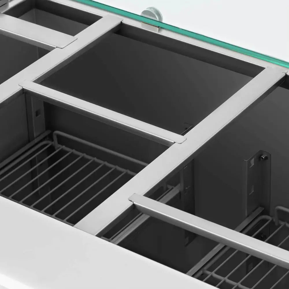 Kjølebord for salat, innvendig oversiktsbilde med gitterhyller, oppdelte rom og glassplate øverst.