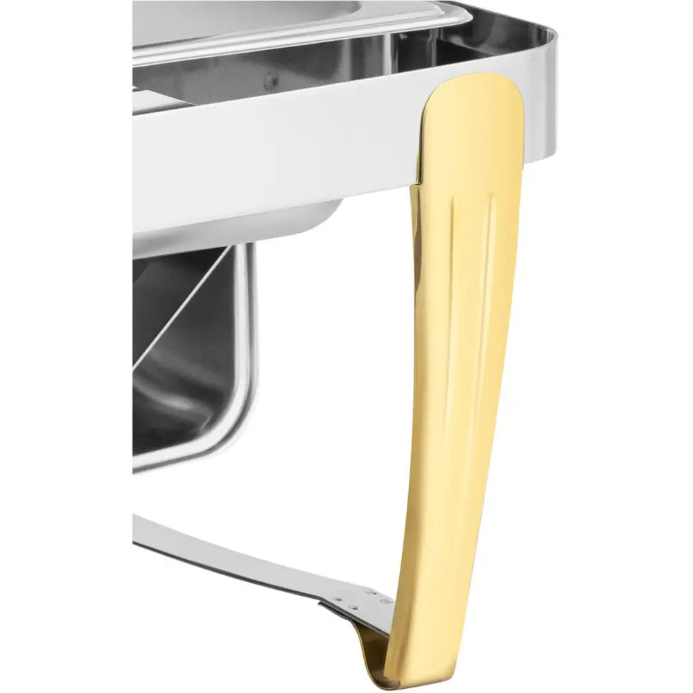 Kjøler for mat på bordet, detaljvisning av gullfarget metallben mot blankt rustfritt stål med sølvinnfelling.