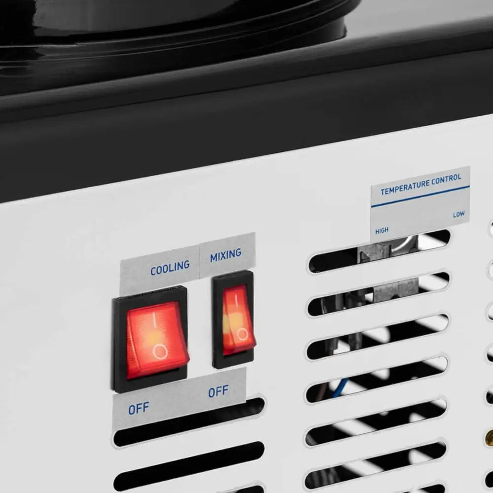 To hvite vippebrytere med rød lysindikator for kjøling og omrøring på metallpanel, nær ventilasjonsgitter.