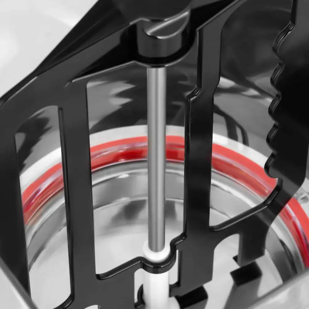 Kjølerdispenser, nærbilde av metallbolle med rødt gummibånd og sentrert metallstang omgitt av sorte plastdetaljer.