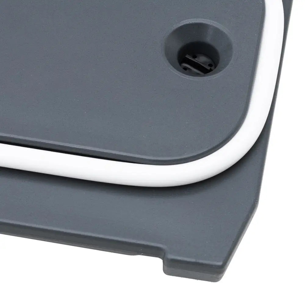 Kjølerom med tappekran, nærbilde av sort innsats i rundt hull på grå plast med hvit kantlist.