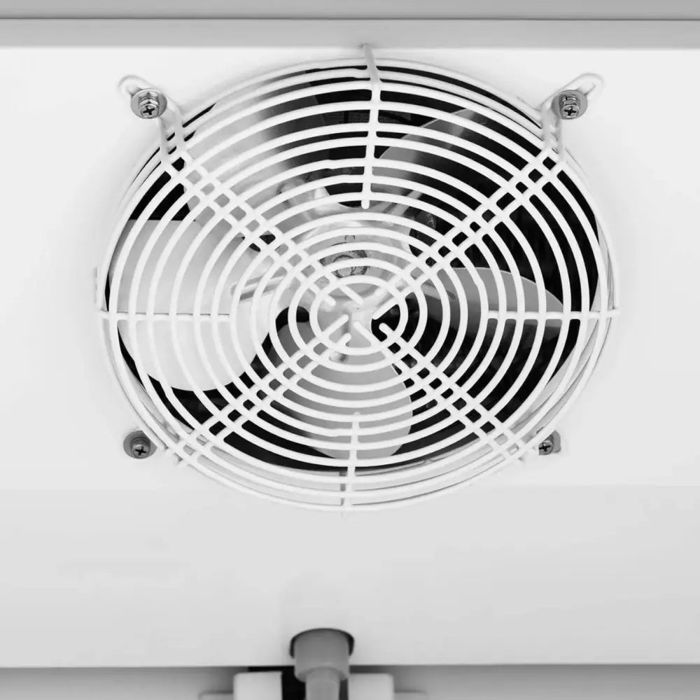Kjølerom skap kjøl, nærbilde av hvitt ventilasjonsgitter med svart vifteblad og fire synlige festeskruer.