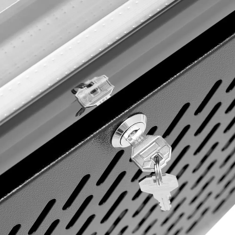 Kjøleskap bar kjøler, nærbilde av sølvfarget nøkkellås med to nøkler og ventilasjonshull i svart metall.