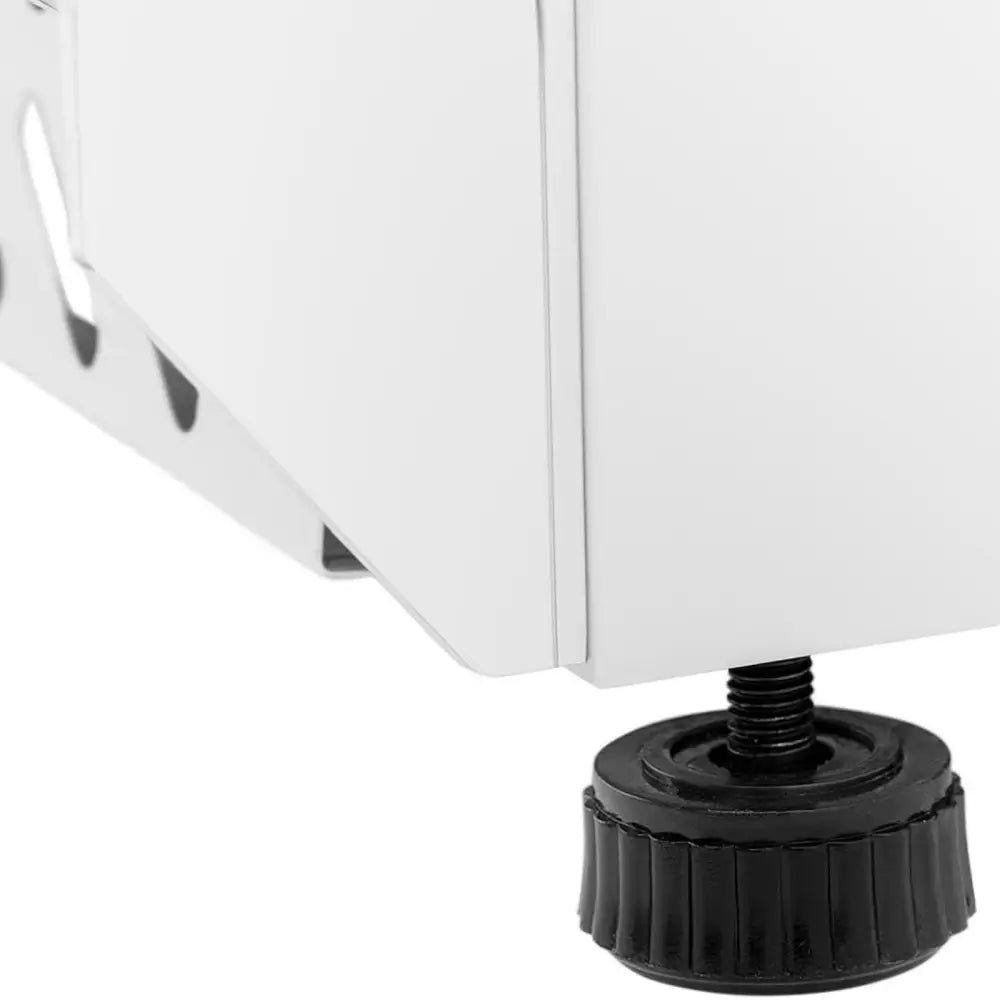 Justerbar sort plastfot med synlig skrue under hvitt kjøleskap, detaljert sidebilde av understellet.