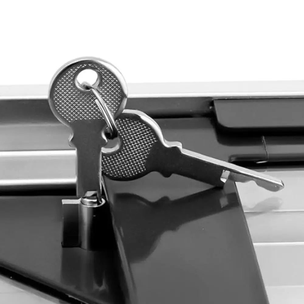 To stålnøkler på nøkkelring, nærbilde oppå sort overflate med låsebeslag til kjøleskap skapfryser.