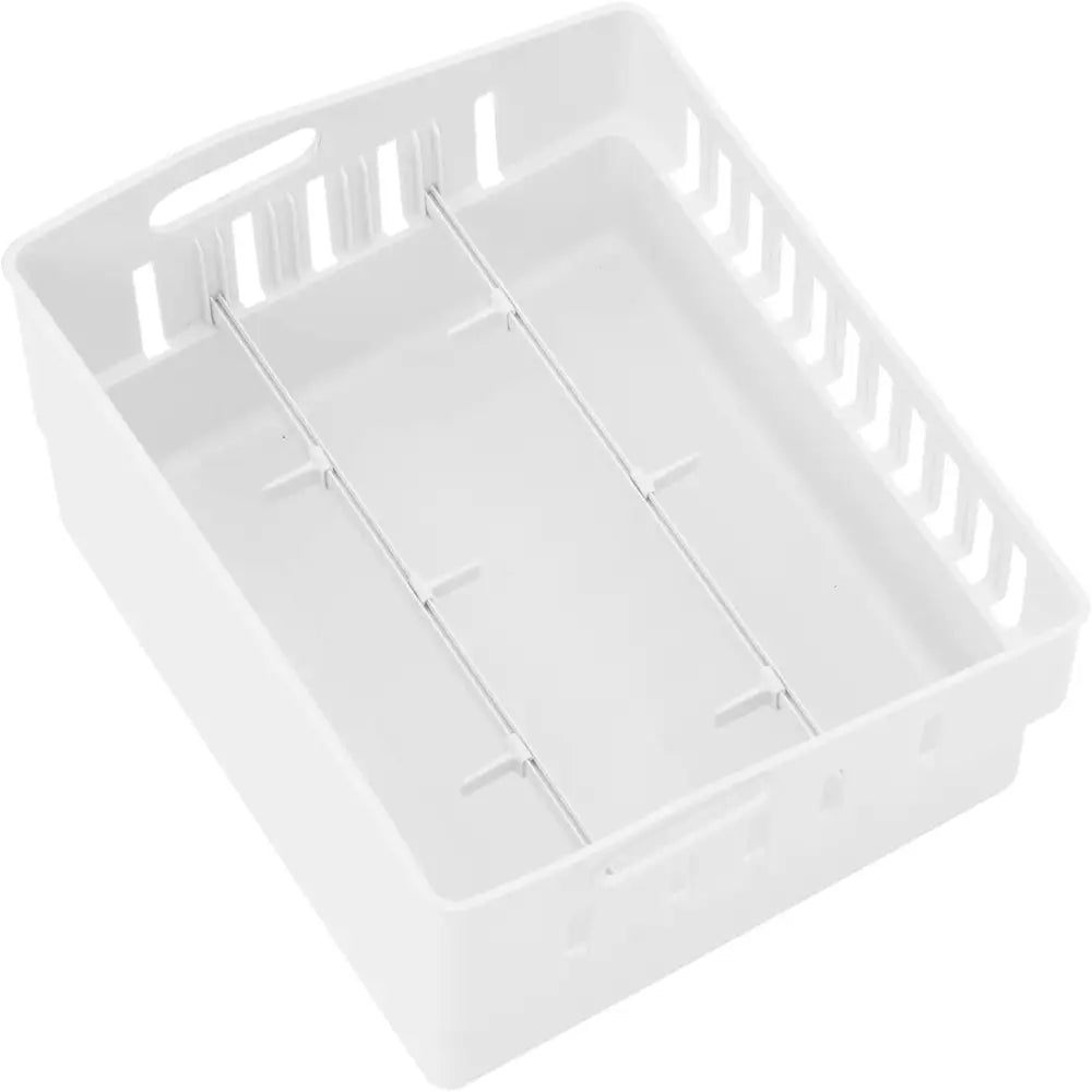 Hvit plastkurv til hotellkjøleskap, sett skrått ovenfra med synlige skillevegger og ventilasjonsåpninger.