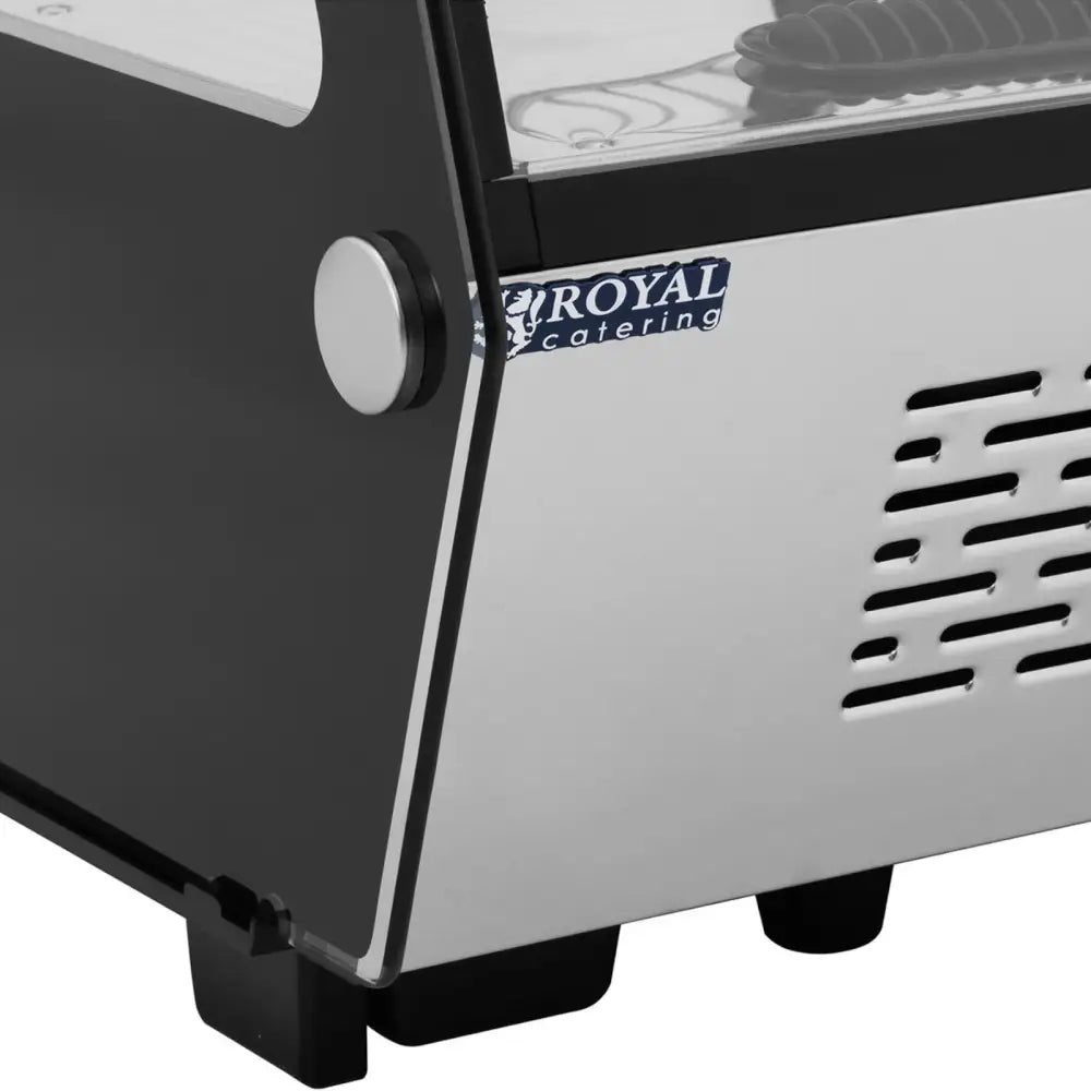 Kjølethylle med glassfront, nærbilde av rustfritt hjørne med ventilasjonshull og synlig merkeetikett.