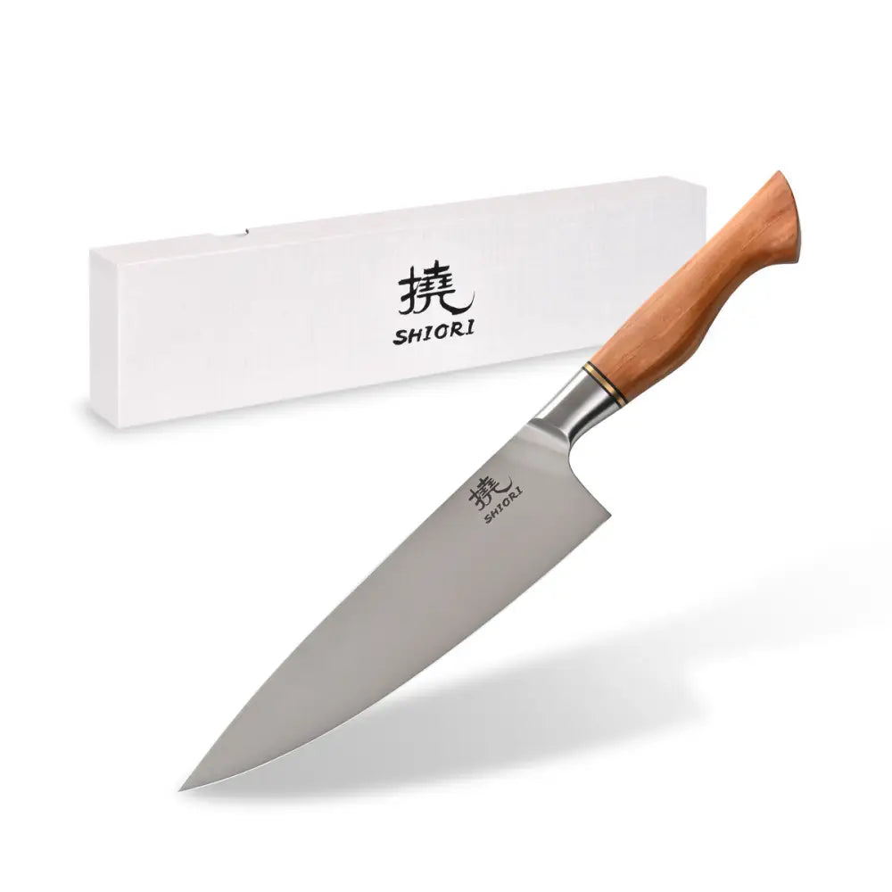 Klassisk kjøkkenkniv Shiori 撓 Shibuki Sifu med lyst trehåndtak, sett fra siden foran gaveeske.