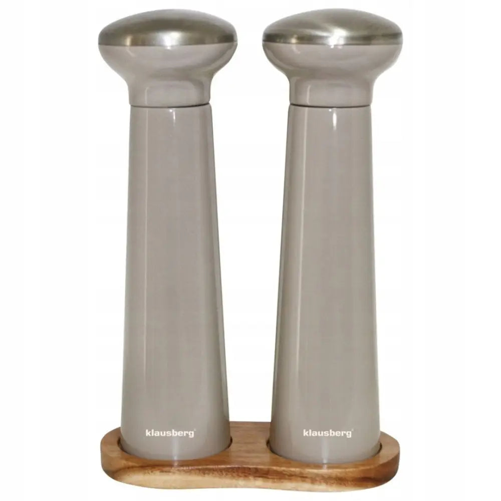 Pepper- og saltkvernsett i grå keramikk med ståldetaljer, plassert på lyst rektangulært trefat.