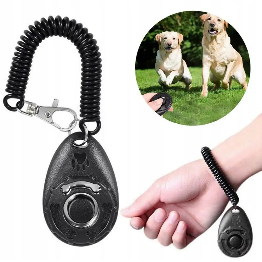 Klikker for trening av hund og valp 2574, svart plast med spiralarmbånd og potetrykk, vises på håndledd med hunder ute.
