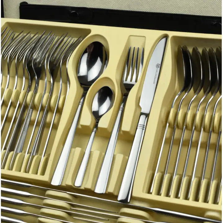 Komplett bestikksett i rustfritt stål, oversiktsbilde av alle deler sortert i beige innsats med egne rom.