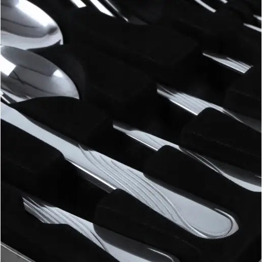 Bestikksett i sølvfarget metall, nærbilde av blank overflate og subtilt mønster på skaftet i skuminnsats.