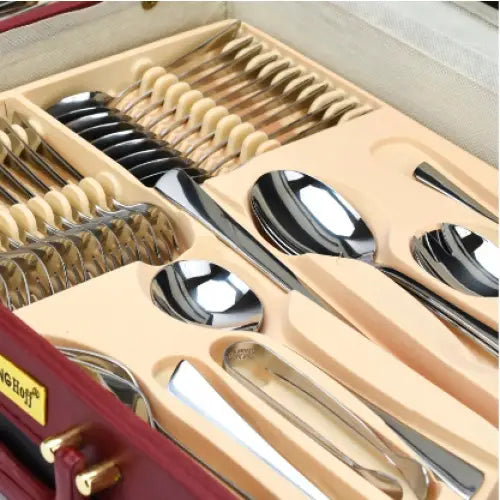Bestikksett i rustfritt stål, skråvisning av gafler, kniver og skjeer organisert i rød koffert.