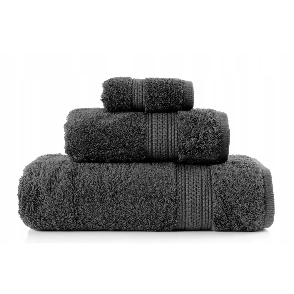 Komplett håndklesett Greno i mørkegrått, tre myke håndklær med dekorative striper, stablet i størrelseorden.