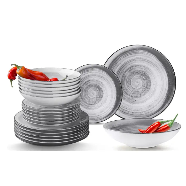 Komplett porselensservise med grå og hvite spiralmønstre, skrå vinkel, boller med røde chilipepper.