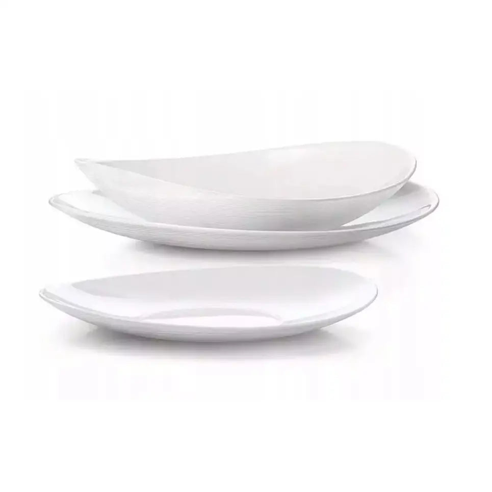 Komplett servise sett, tre hvite ovale porselenstallerkener stablet fra siden med fokus på buet form.