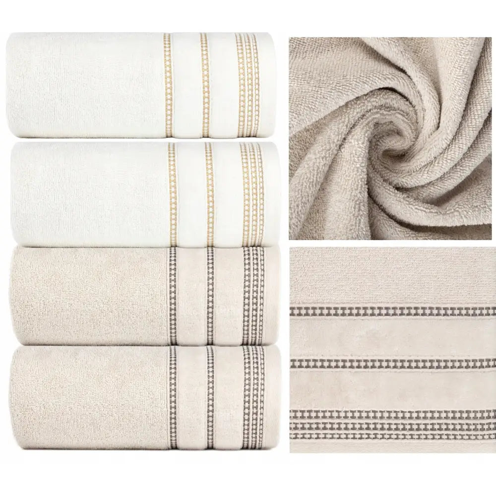 Komplett sett med fire luksuriøse bomullshåndklær, nærbilde av myk frotté og broderte gull- og grå striper.
