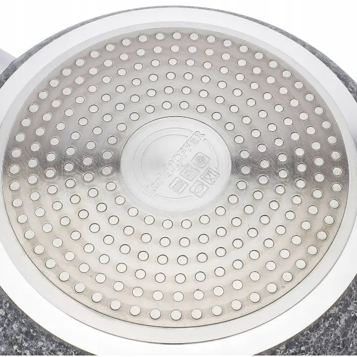 Bunnen av Konighoffer stekepanne i rustfritt stål, sett nedenfra med sirkulært perforert mønster og gravering.