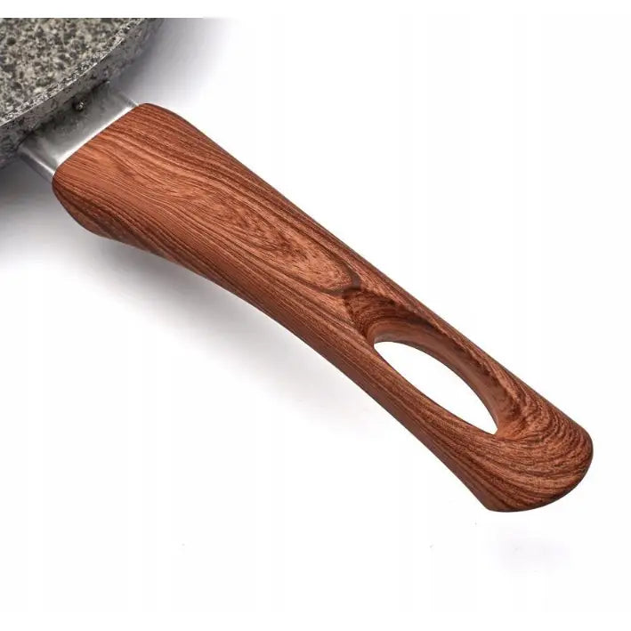 Ergonomisk håndtak i trelook med oval åpning, festet til grå stekepanne med steinmønstret overflate.