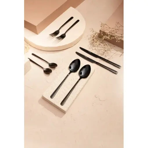 Komplett Lugano bestikksett i matt svart metall, sett ovenfra på lyse underlag med moderne design.