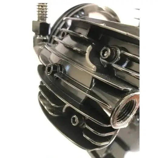 Kompressor 300L, nærbilde av svart metallkomponent med kjøleribber og gjengede hull sett fra siden.