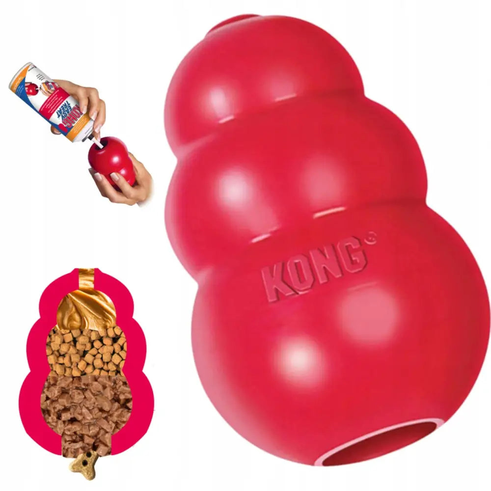 Kong Classic Original tyggeleke størrelse L, rød gummi vist med fyll og hånd som legger godbiter i åpningen.