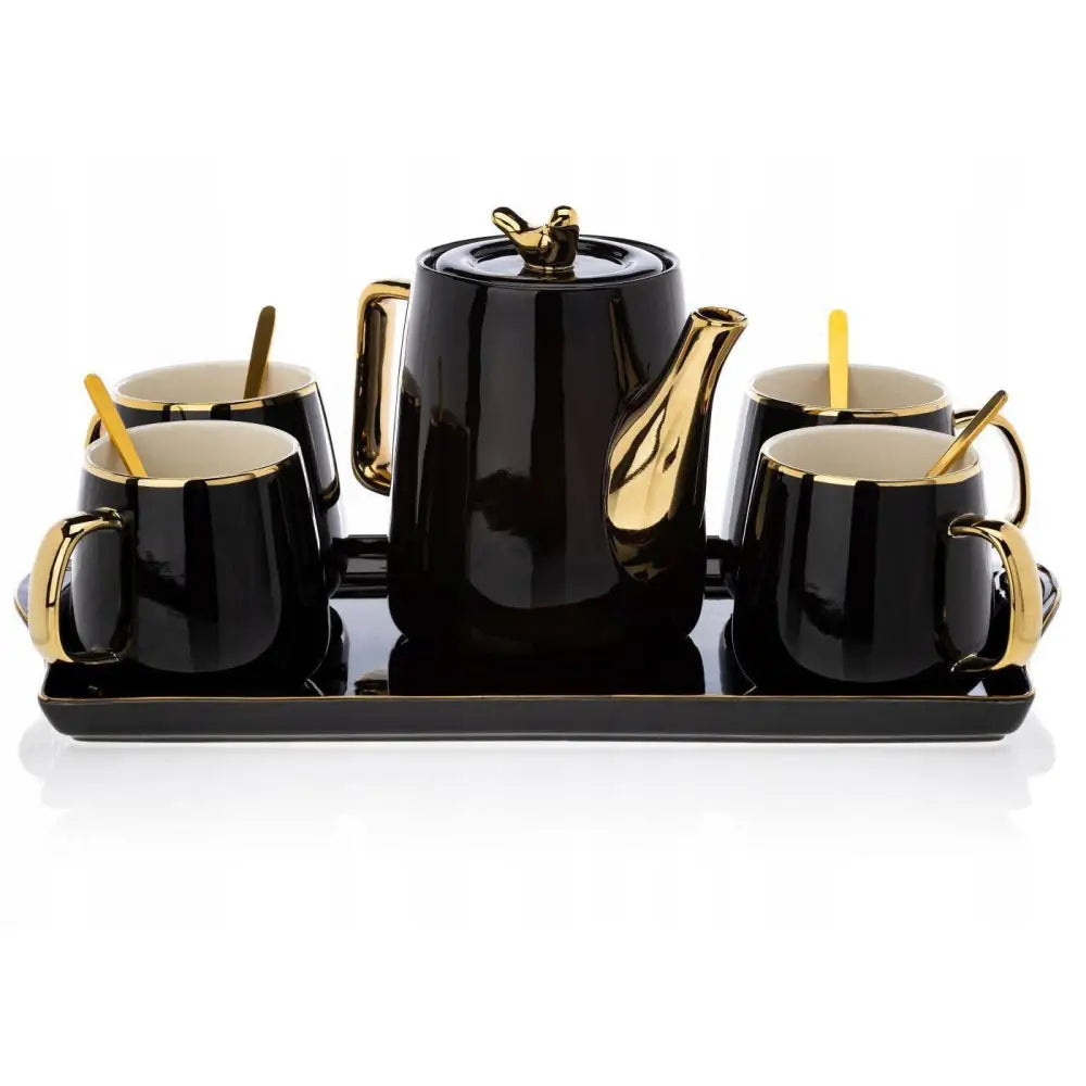 Kopper med tekanne sett i svart med gullfargede detaljer, plassert samlet på elegant rektangulært brett.