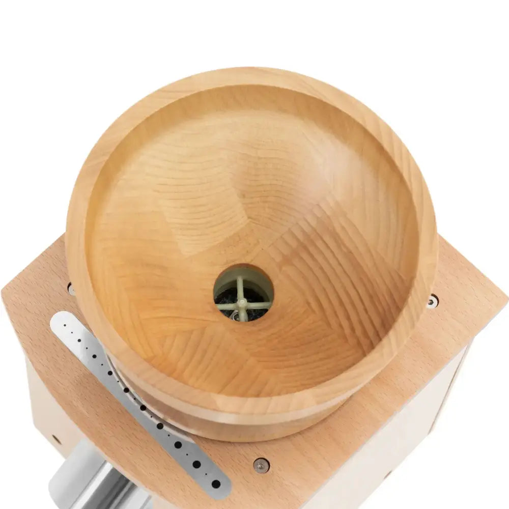 Kornmølle i lyst tre, toppvinkel som viser sirkulært beger og synlig hvit maleverk i midten.