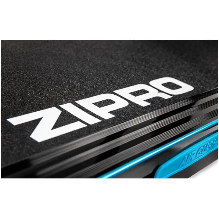 Tredemølle Zipro Notus, nærbilde av sort, teksturert overflate med hvit logo og blå detalj nederst.