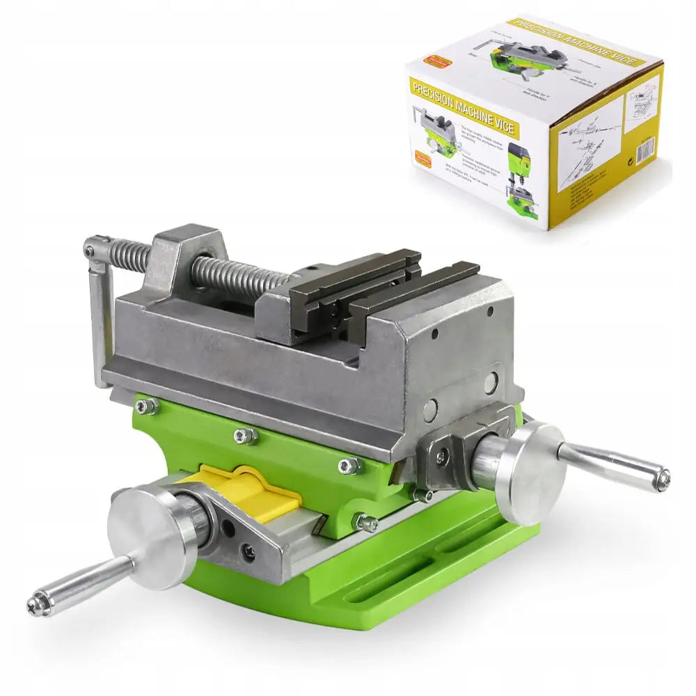 Krysshold fast til borddrill, metallisk skrustikke med grønne og gule detaljer, sett skrått med eske bak.