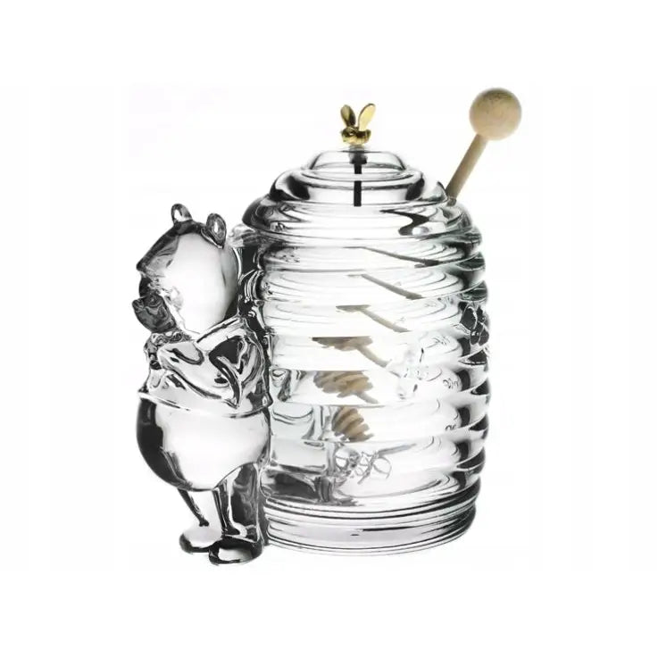 Krystall honningkrukke formet som bikube, med bjørnefigur og honningdippe, sett fra skrå vinkel.