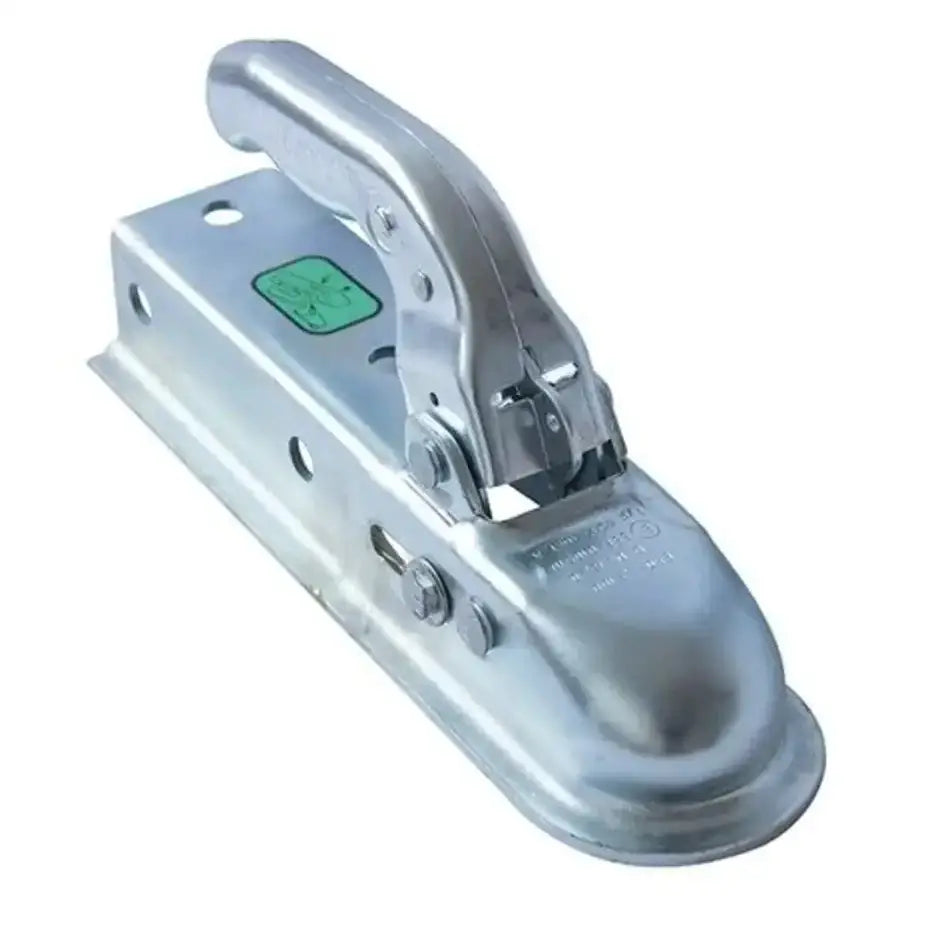 Kulekobling for tilhenger, sølvfarget med løftehåndtak og grønn etikett, sett fra siden mot hvit bakgrunn.