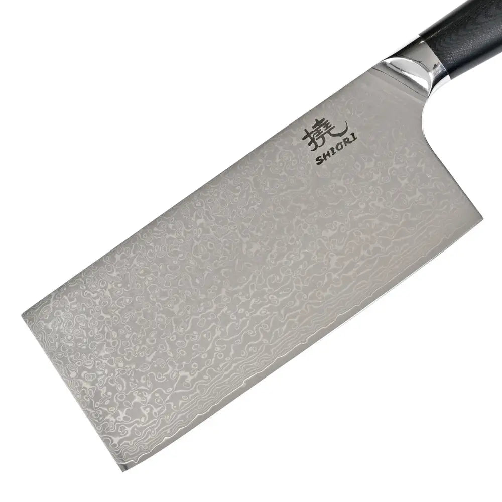Kokkekniv i Damaskus-stål, skråvisning som fremhever det unike damaskmønsteret og graveringen nær håndtaket.