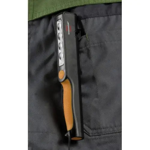 LED Pen Light, svart og oransje, festet i bukselomme med synlig LED-panel og av/på-knapp fra siden.