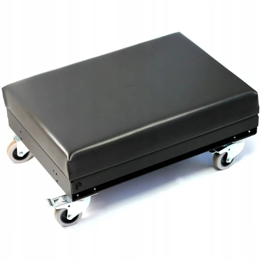 Lavt sitteunderlag knelingsdetaljeringsstol, sort pute på lavt rullestativ sett skrått fra siden.