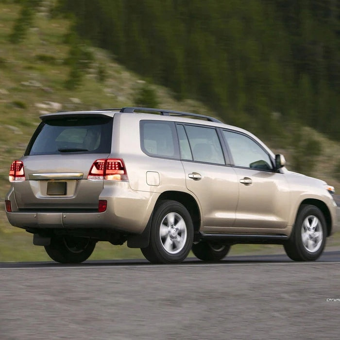Gullfarget Land Cruiser 200 på vei med røkfargede baklykter.