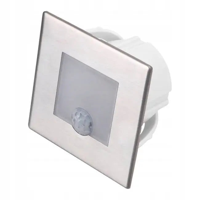 LED trappelys med kvadratisk børstet sølvfront, synlig sensor og frostet midtfelt, sett fra skrå vinkel.