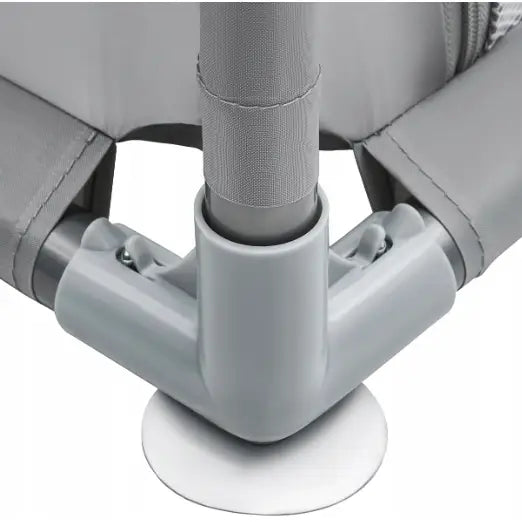 Grått hjørnebeslag med sugekopp og tekstiltrukket stolpe, detalj fra lekegrindens robuste rammefeste.