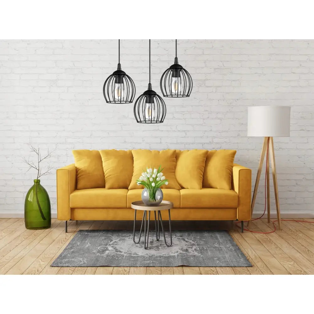 Loft hengende lampe i netting, kuleform, over stue med sennepsgul sofa, blomsterbord og moderne interiør.
