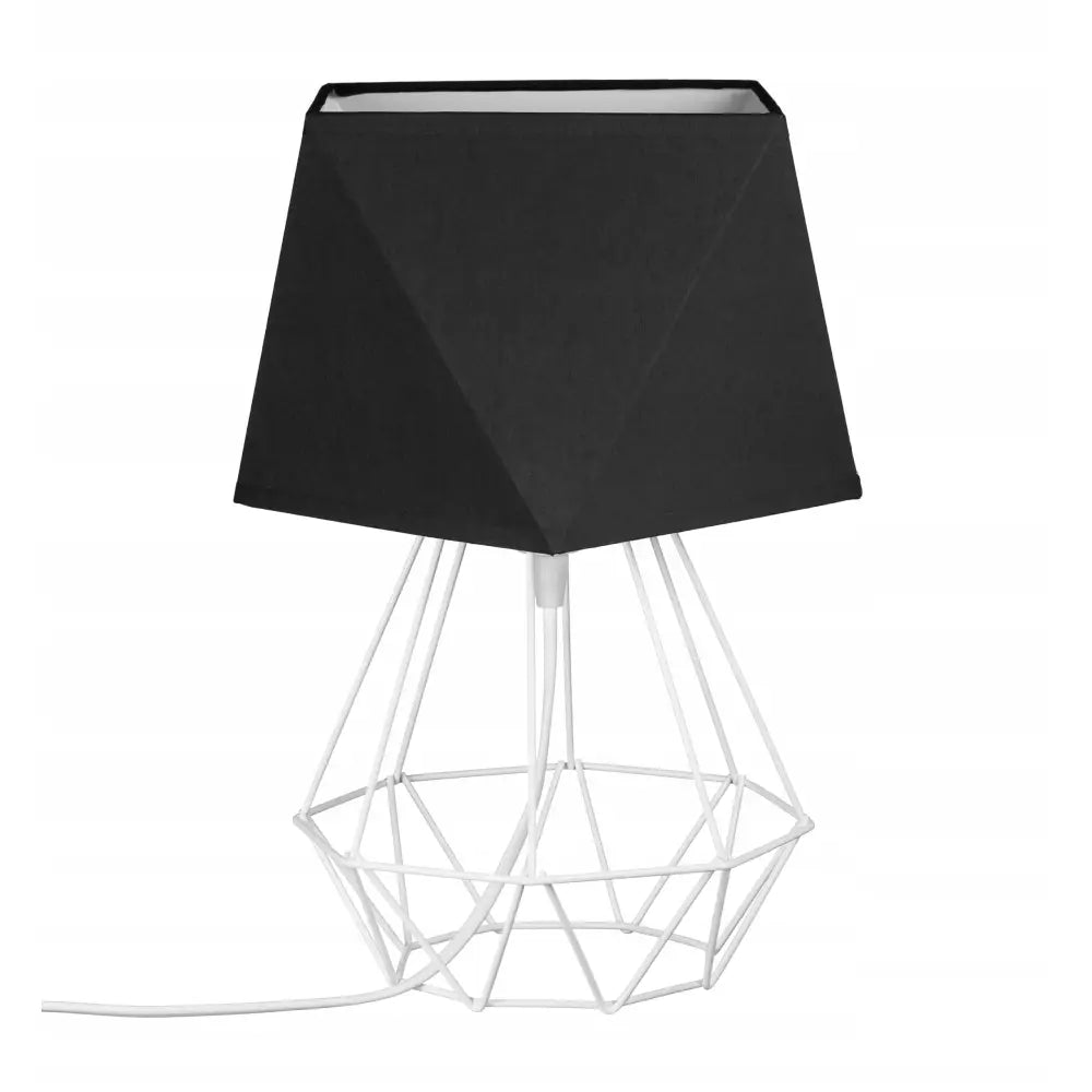 Loft nattlampe med sort diamantformet trådskjerm og hvit metallfot, ledning synlig mot hvit bakgrunn.