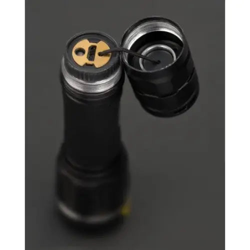 Lommelykt LED LuxPremium TL, nærbilde av åpen bakende med synlig kontaktplate og ledning mot mørk bakgrunn.