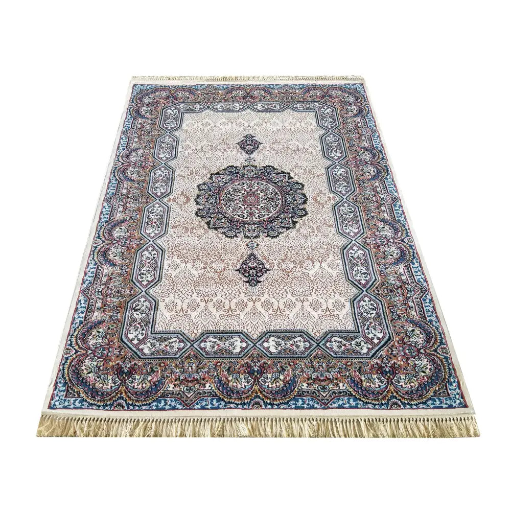 Iransk teppe i krem, orientalsk mønster i beige, blå og burgunder, sett fra skrå vinkel med lyse frynser.