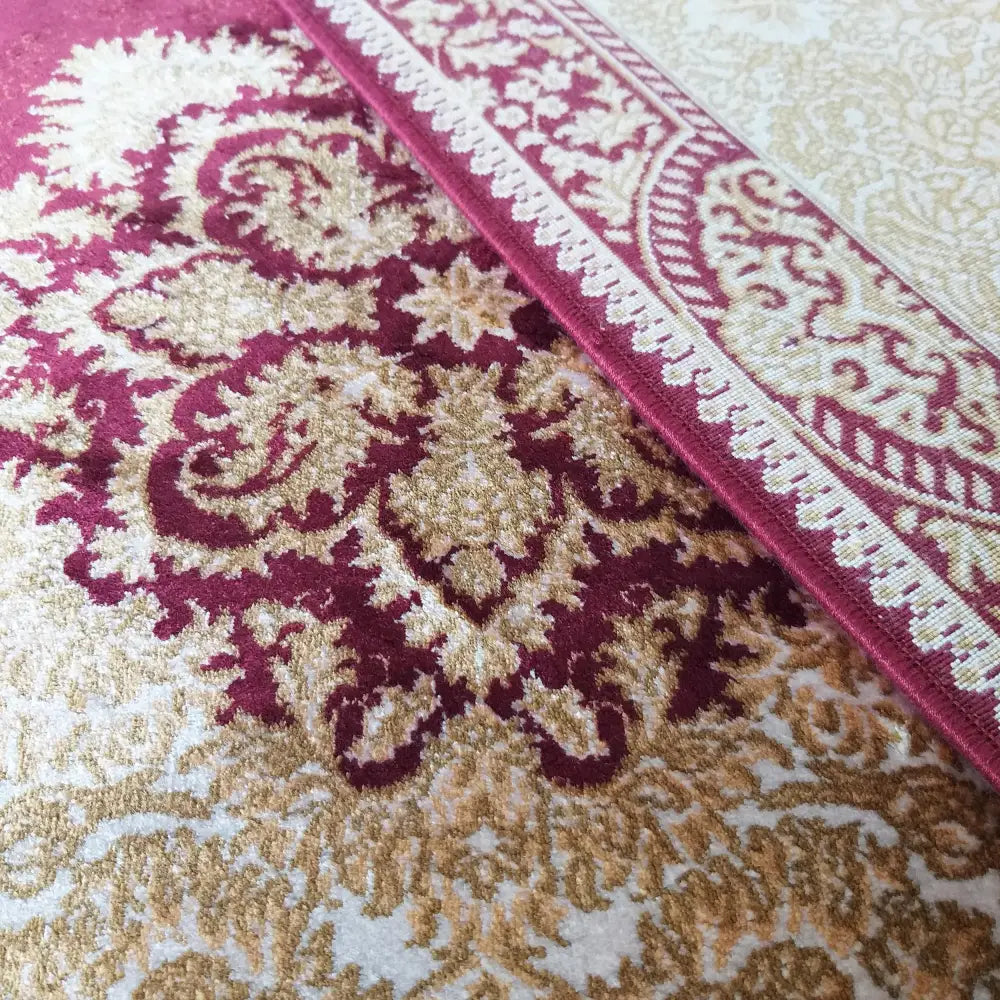 Qum Silk 02 teppe i burgunder, beige og gull, nærbilde som viser detaljert orientalsk mønster og fibrenes tekstur.