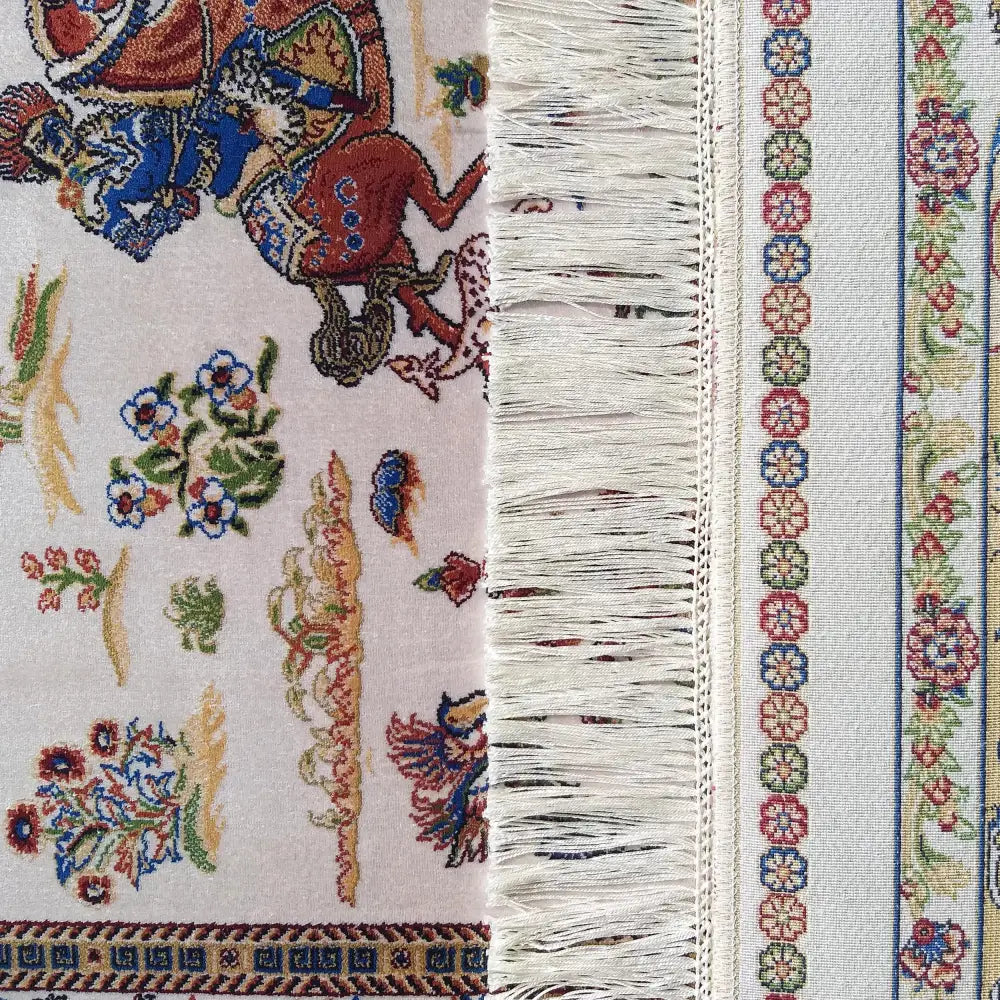Qum Silk kremet teppe, nærbilde av fargerikt orientalsk mønster og lyse frynser langs kanten.