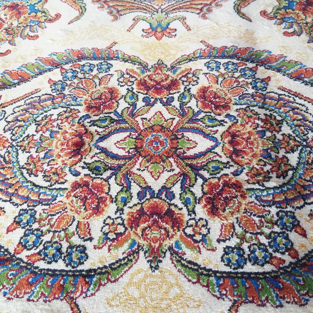Qum Silk Tepe i krem, nærbilde som fremhever fargerikt blomsterdesign og teppets detaljerte vevstruktur.