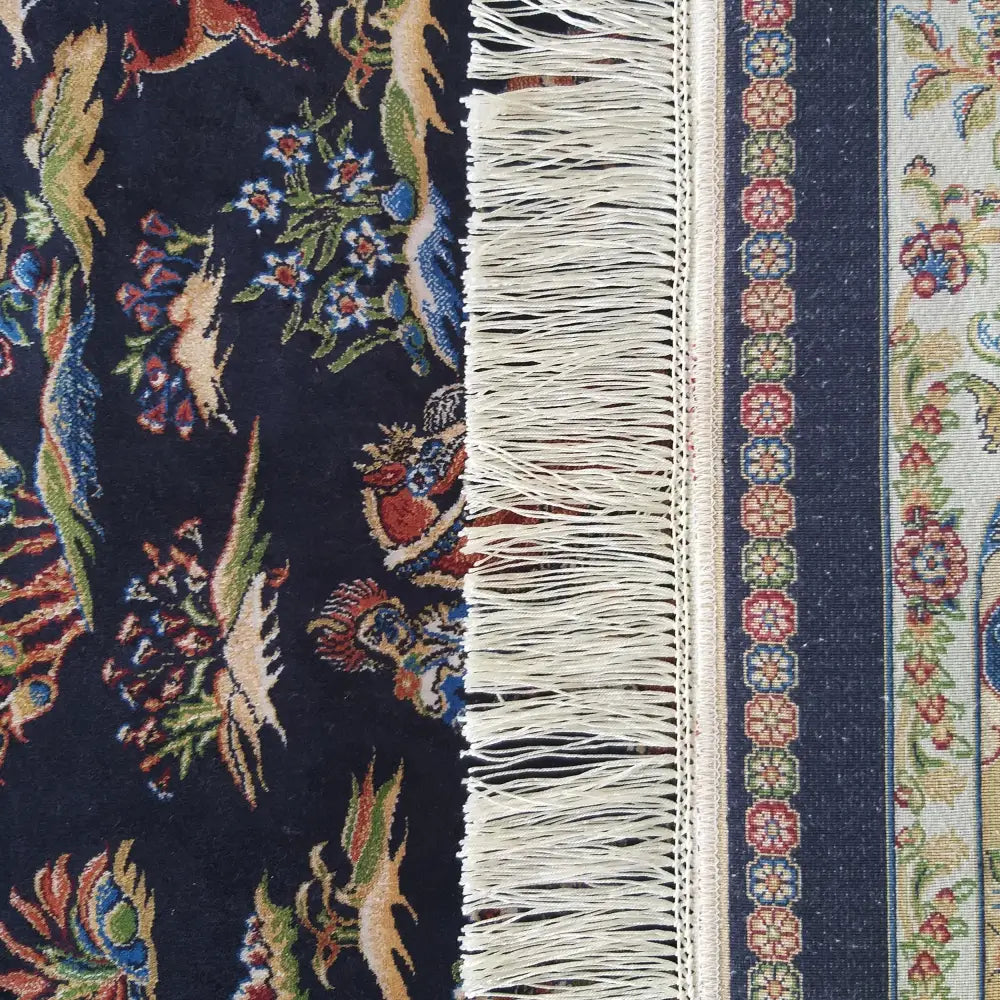 Qum Silk Tepe i navy, nærbilde av floralt mønster, dekorativ bord og hvite frynser sett ovenfra.