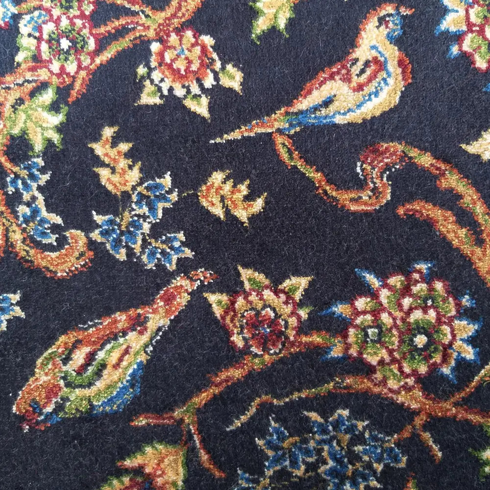 Qum Silk Tepe teppe, detalj av marineblått stoff med fuglemotiver og fargerike blomster.
