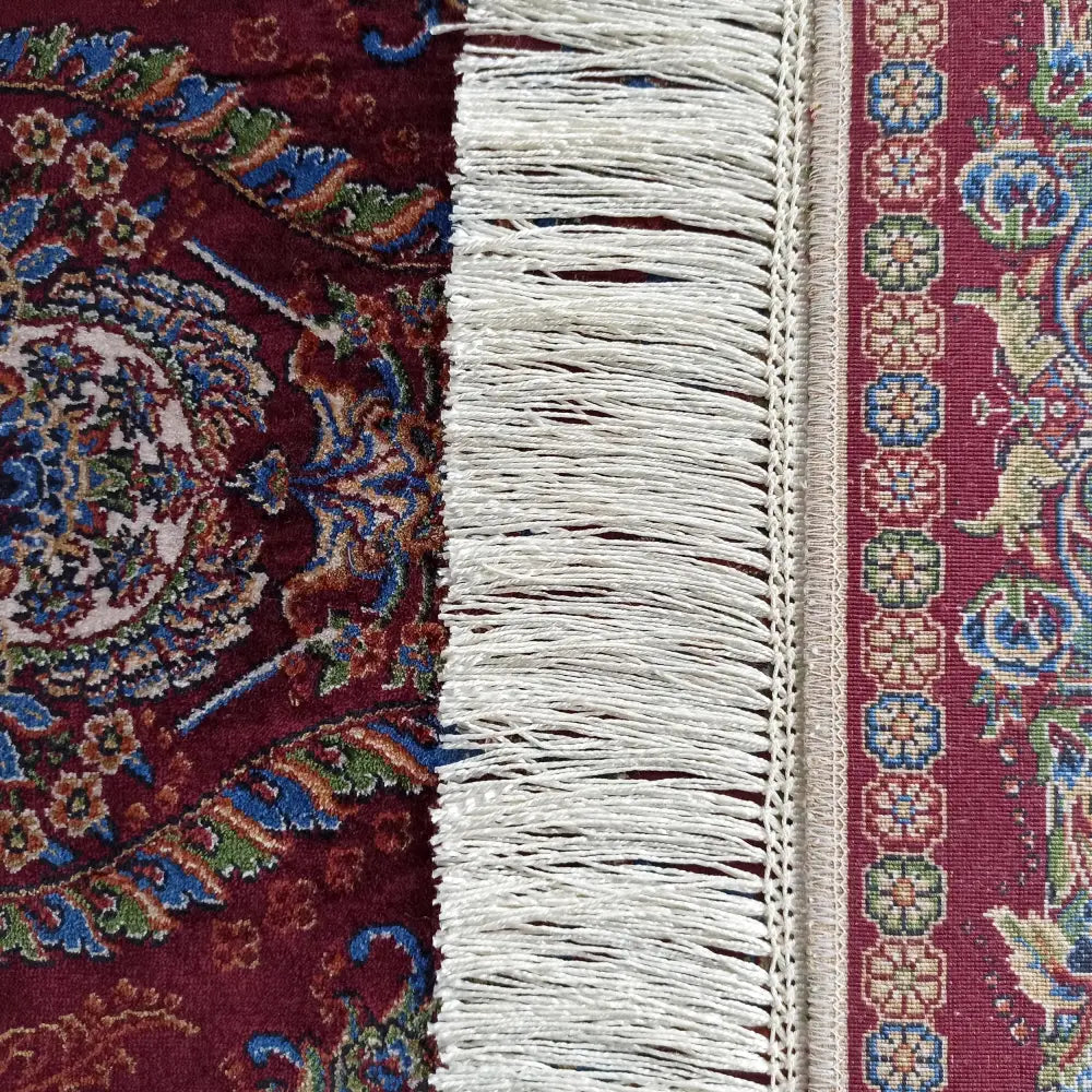 Qum Silk Tepematte i burgunder med orientalske mønstre, nærbilde som fremhever tekstur og hvite frynser.