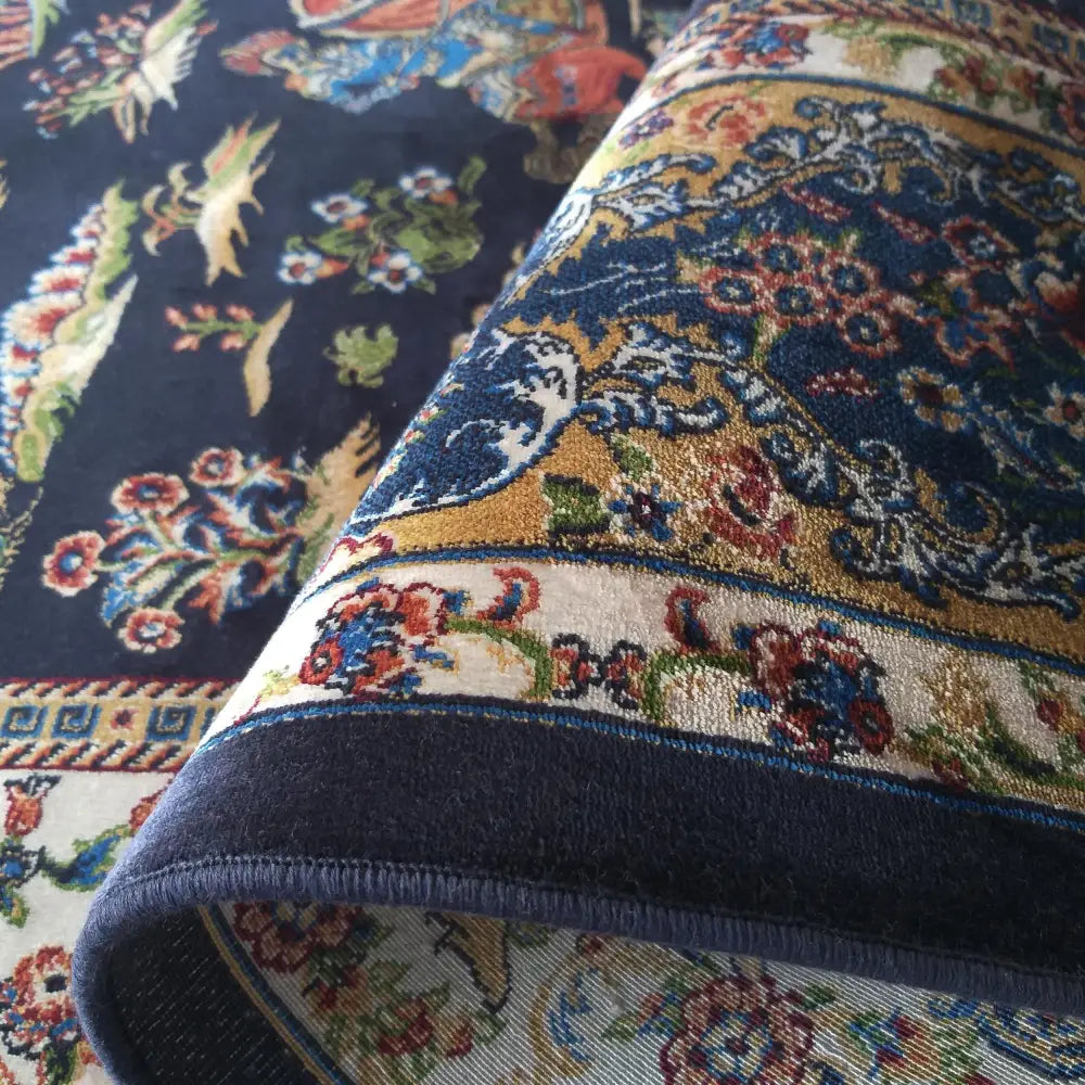 Luksuriøst Qum Silk Tepenavy-teppe, detaljert nærbilde av blått og gull blomstermønster og dekorativ kant.