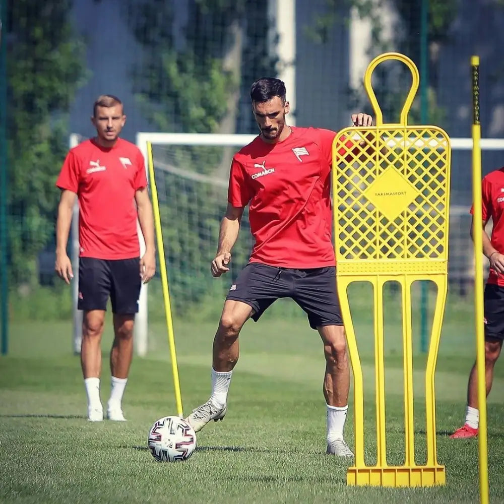 Mål Fodboldnett ELITE 180 cm, utendørs fotballtrening med to menn og gul plastmannekin i aksjon.